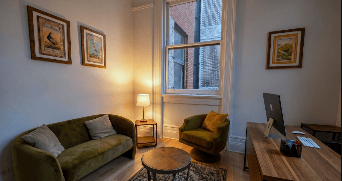 Warm living-room-style therapy room with a green sofa and side table